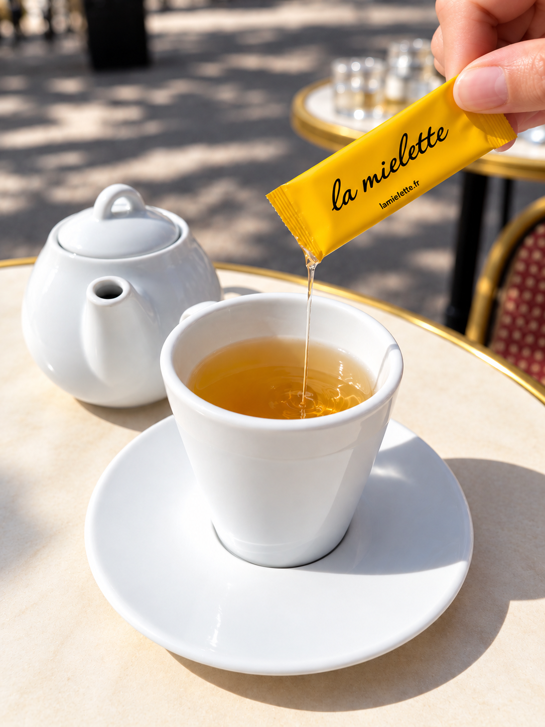 Un sachet la mielette versé dans une tasse de thé